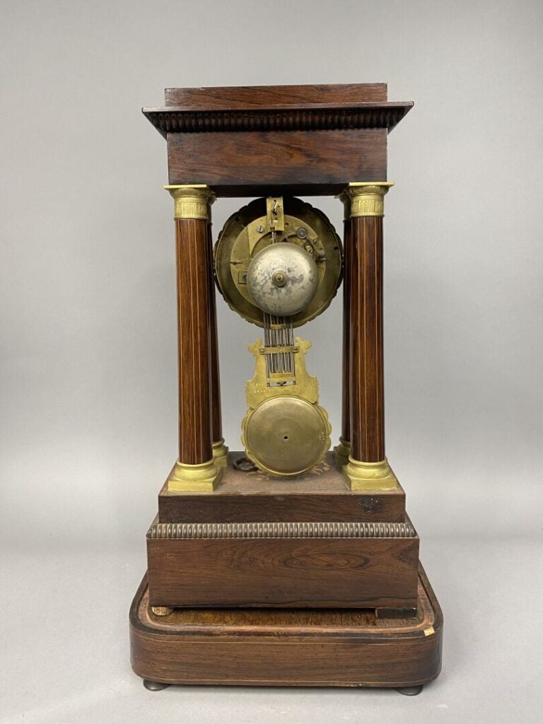 Pendule portique en palissandre à décor marqueté de bois clair à décor de rince…