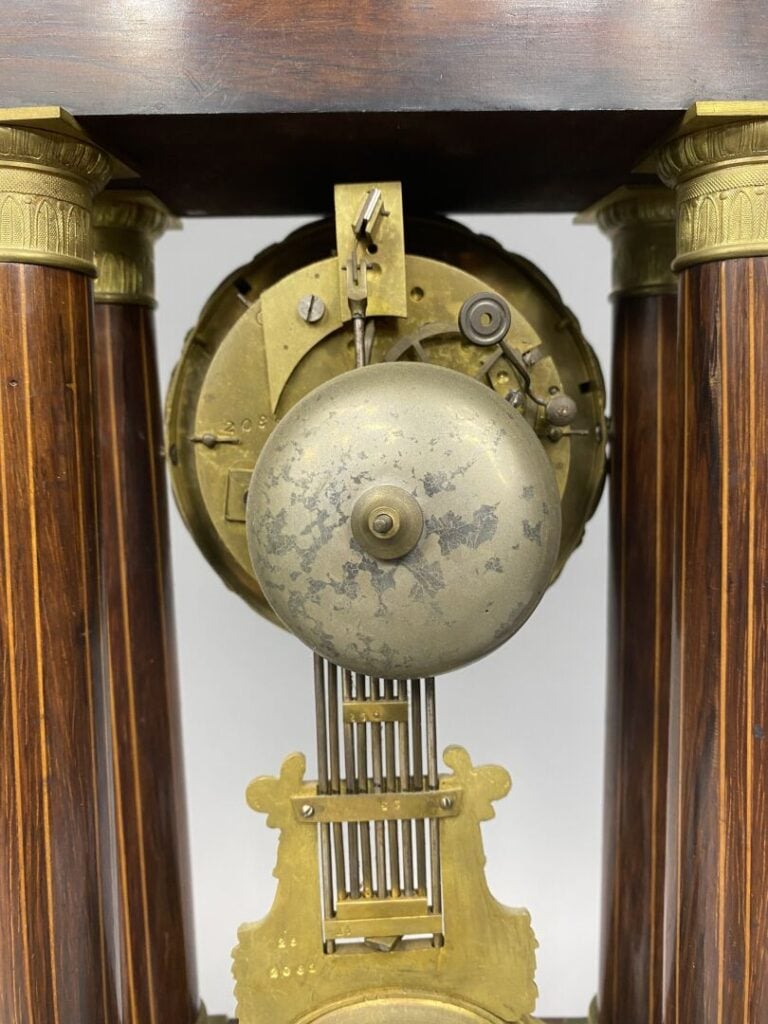 Pendule portique en palissandre à décor marqueté de bois clair à décor de rince…