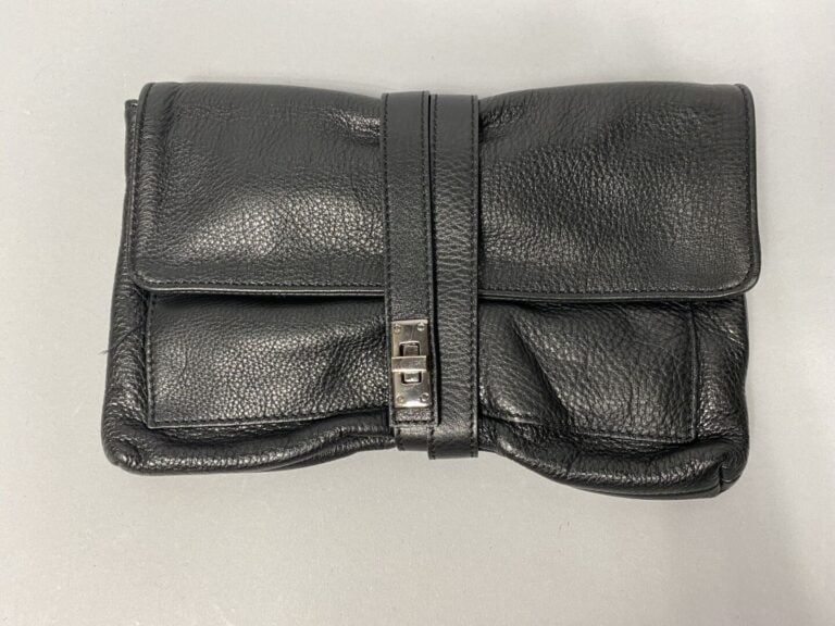 Pochette en cuir noir grainé, se ferme par un double lien et un fermoir pivotan…