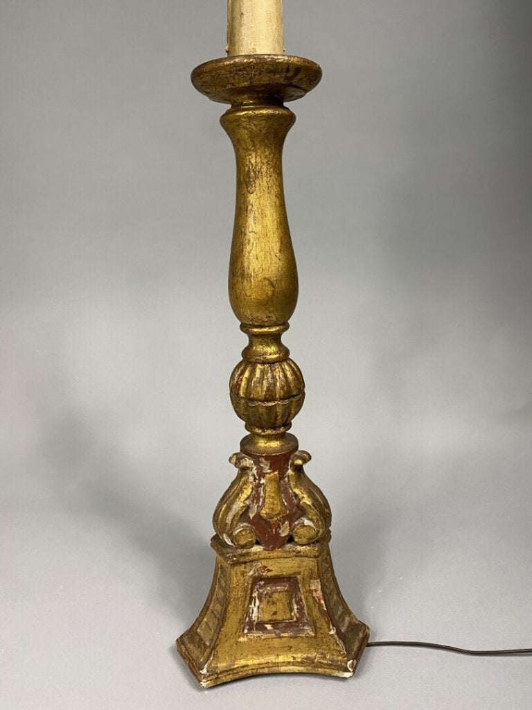 Porte-torchère en bois sculpté et peint doré, le fût balustre à godrons posant…
