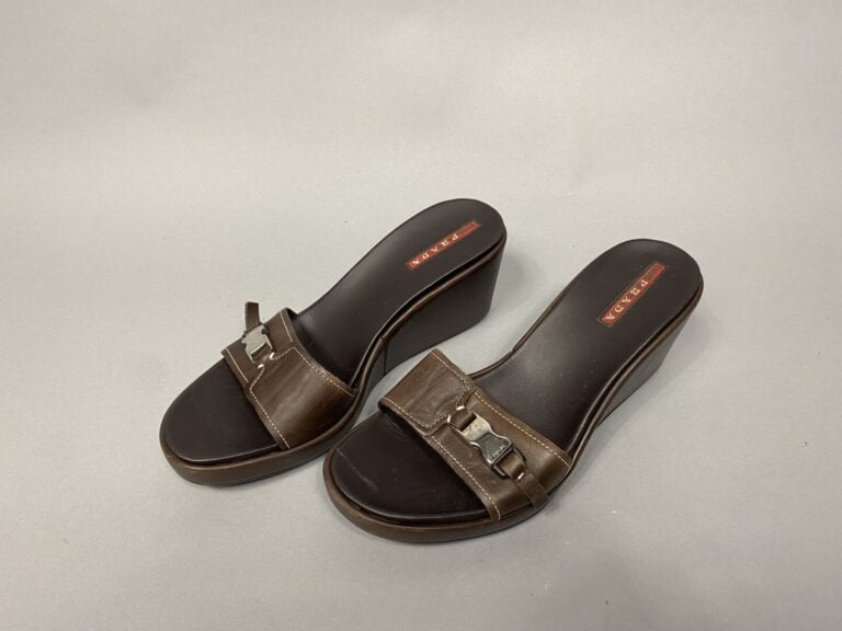 PRADA - Paire de mules compensées en cuir marron, fermoir clip sur le dessus en…