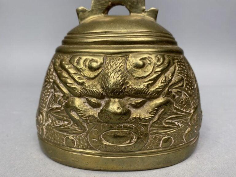 Vietnam - Cloche en bronze doré à décor de têtes de dragons parmi volutes nuage…