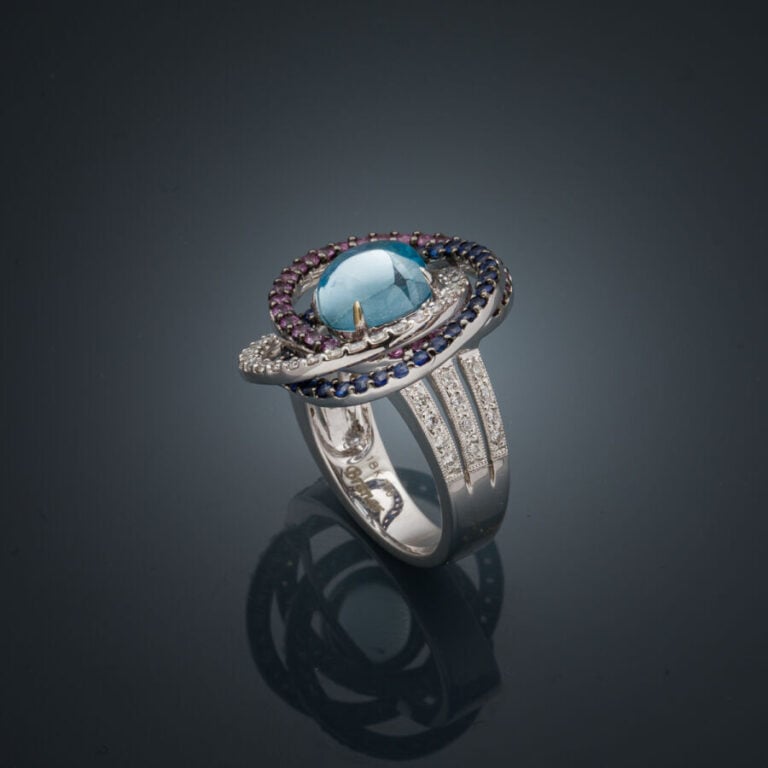 BAGUE "anneaux" en or gris et or noirci (750‰) ajouré, serti d'une topaze bleue…