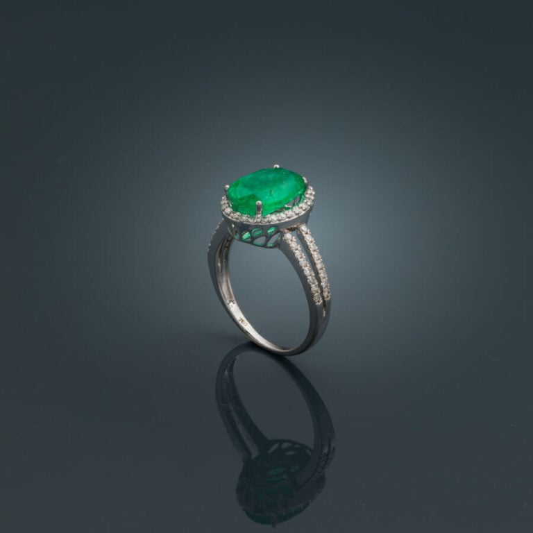 BAGUE en or gris (750‰) ajouré, serti d'une émeraude ovale, entourée et épaulée…