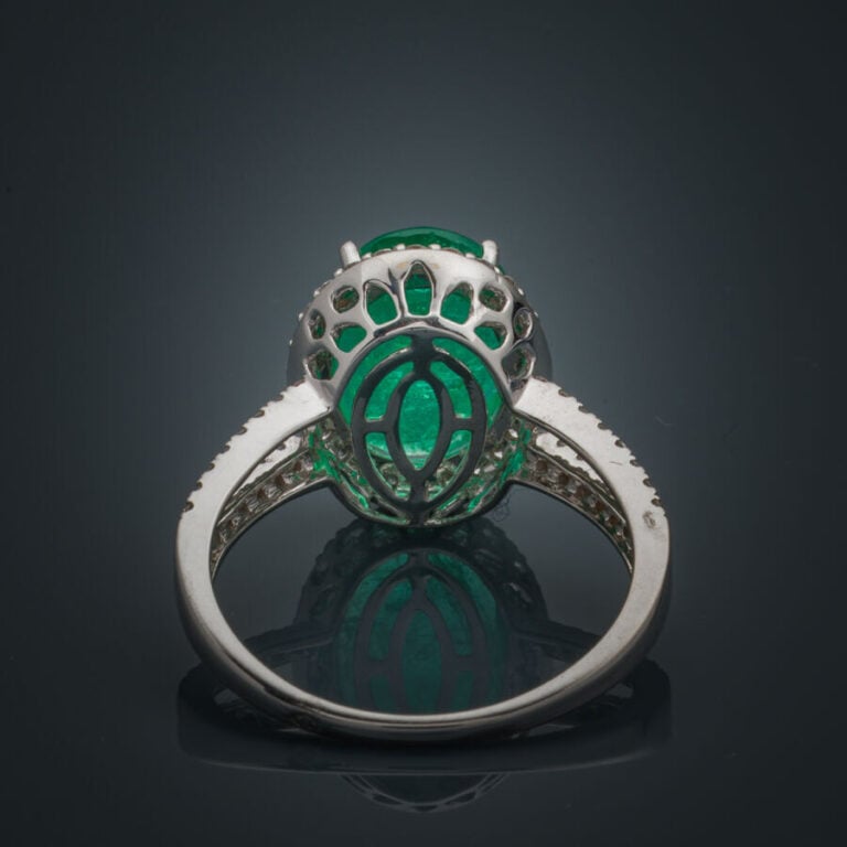 BAGUE en or gris (750‰) ajouré, serti d'une émeraude ovale, entourée et épaulée…