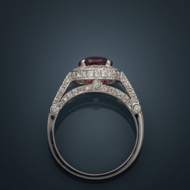 BAGUE en or gris (750‰) serti d'un rubis rond entouré et épaulé de diamants tai…