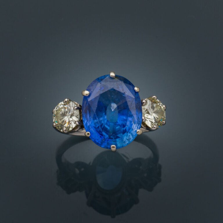 BAGUE en or gris (750‰) serti d'un saphir ovale CEYLAN NON CHAUFFE, épaulé de d…