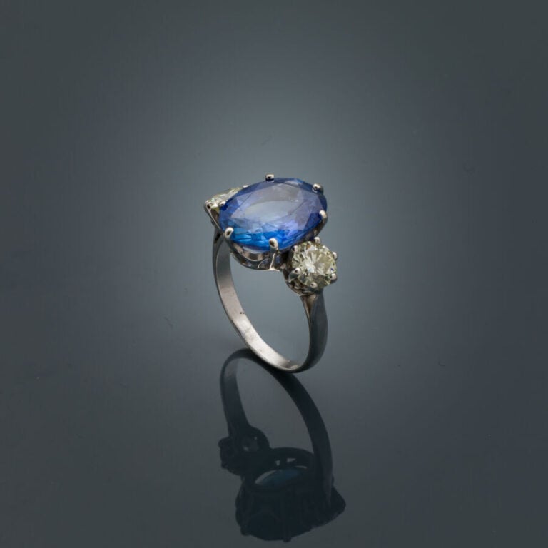 BAGUE en or gris (750‰) serti d'un saphir ovale CEYLAN NON CHAUFFE, épaulé de d…