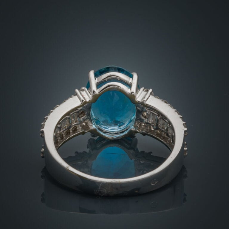 BAGUE en or gris (750‰) serti d'une aigue-marine ovale (chocs), épaulée d'align…