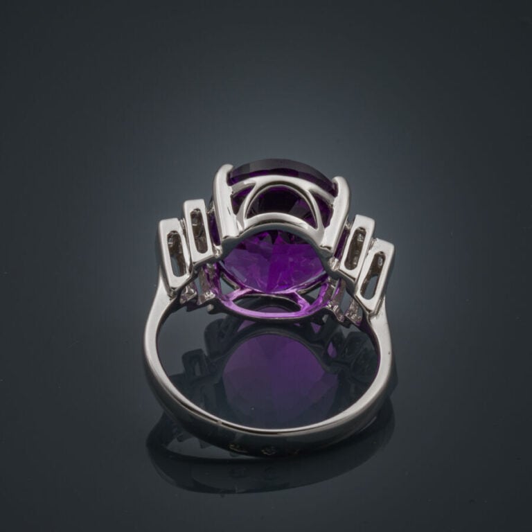 BAGUE en or gris (750‰) serti d'une améthyste ovale épaulée de trois diamants t…