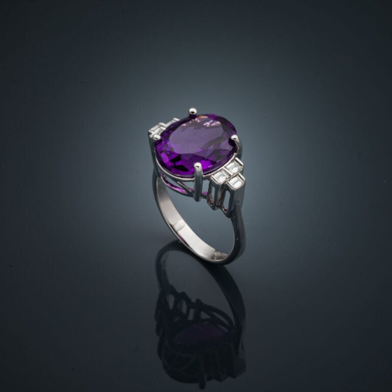 BAGUE en or gris (750‰) serti d'une améthyste ovale épaulée de trois diamants t…