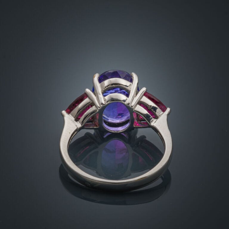 BAGUE en or gris (750‰) serti d'une tanzanite ovale, épaulé de rubellites (tour…
