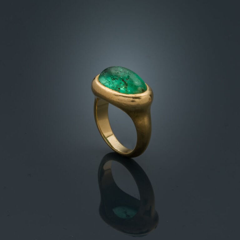 BAGUE en or jaune (750‰) serti d'une émeraude cabochon de forme ovale (chocs et…