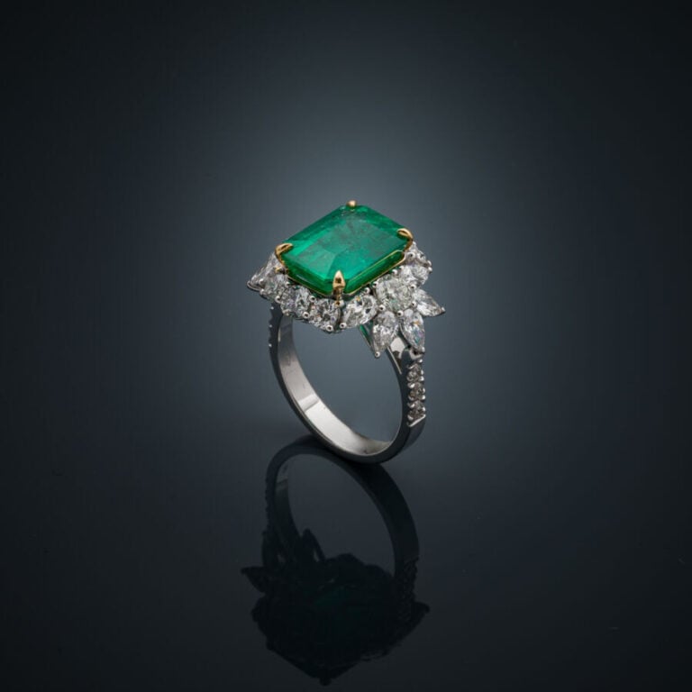 BAGUE en or jaune et or gris (750‰) serti d'une émeraude taillée à degrés entou…