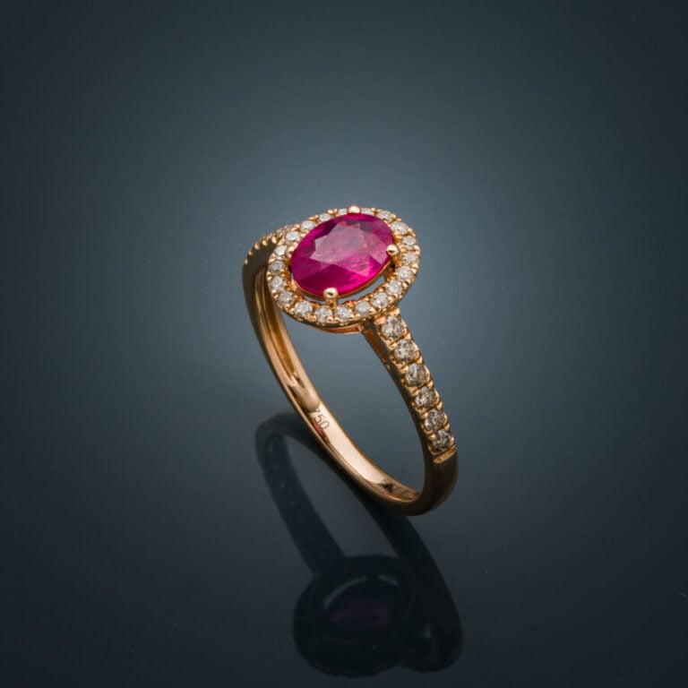 BAGUE en or rose (750‰) serti d'un rubis ovale, entouré et épaulé de diamants t…