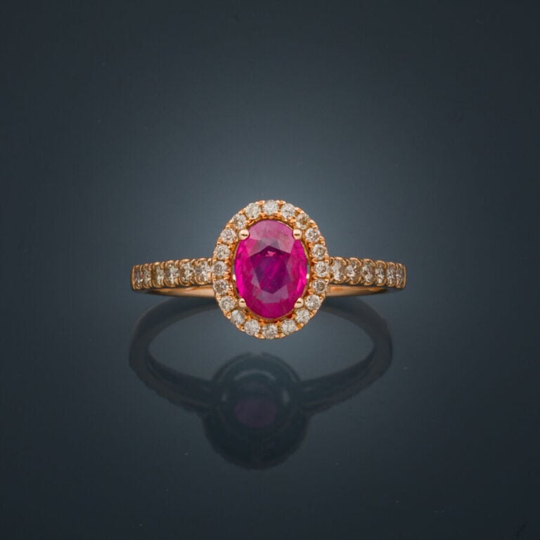 BAGUE en or rose (750‰) serti d'un rubis ovale, entouré et épaulé de diamants t…