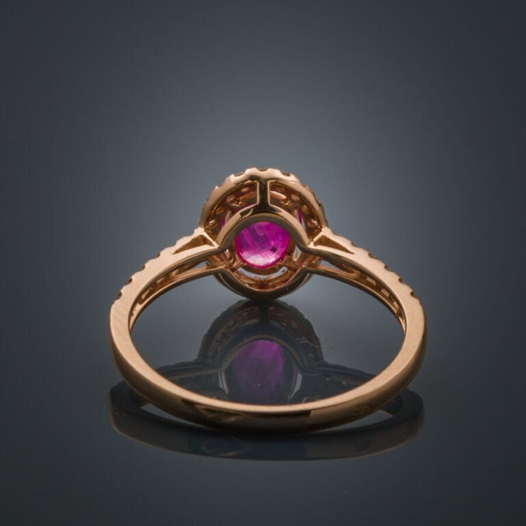 BAGUE en or rose (750‰) serti d'un rubis ovale, entouré et épaulé de diamants t…