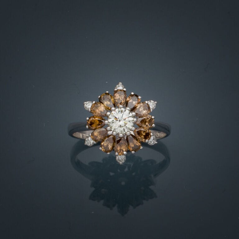 BAGUE "flocon" en or gris (750‰) serti d'un diamant taille brillant entouré de…