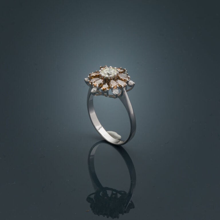 BAGUE "flocon" en or gris (750‰) serti d'un diamant taille brillant entouré de…