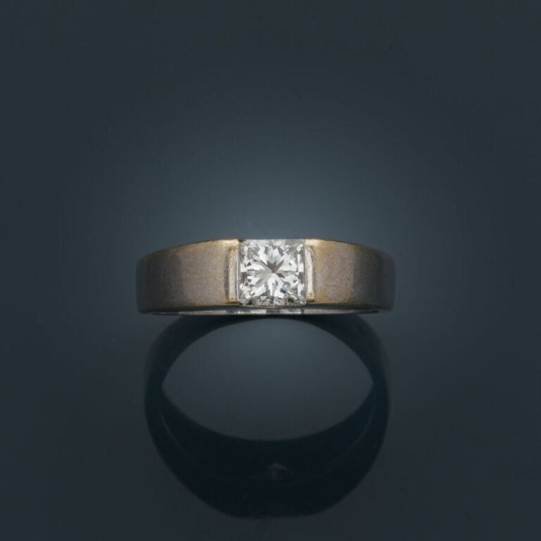 BAGUE "jonc plat" en or gris (750‰) serti d'un diamant taille princesse (choc).…