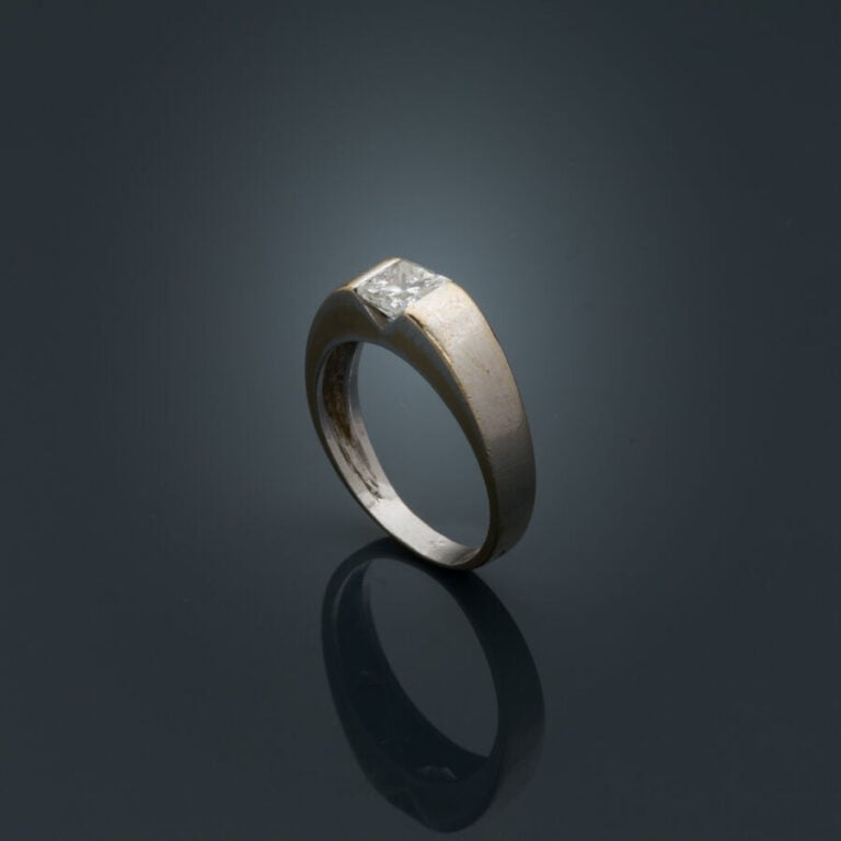 BAGUE "jonc plat" en or gris (750‰) serti d'un diamant taille princesse (choc).…