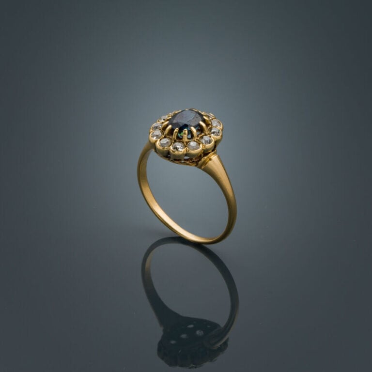 BAGUE "marguerite" en or jaune (750‰) serti d'un saphir de forme ovale, entouré…
