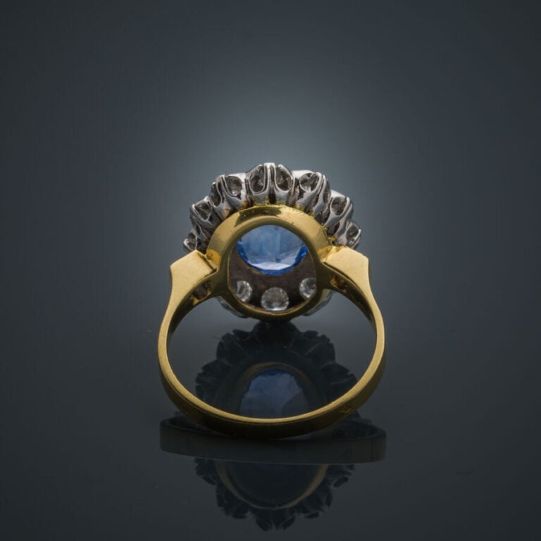 BAGUE "marguerite" en or jaune et or gris (750‰) serti d'un saphir ovale, entou…