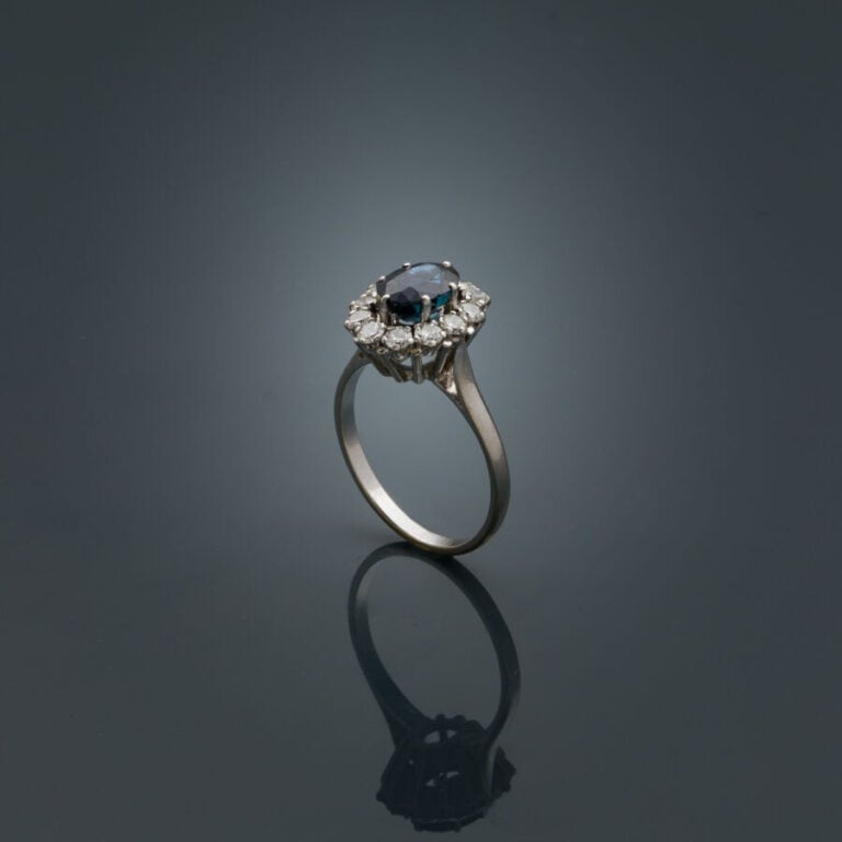 BAGUE "marguerite" en platine (950‰) et or gris (750‰) serti d'un saphir ovale…