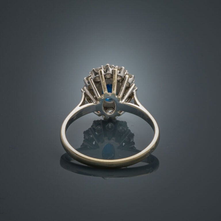 BAGUE "marguerite" en platine (950‰) et or gris (750‰) serti d'un saphir ovale…
