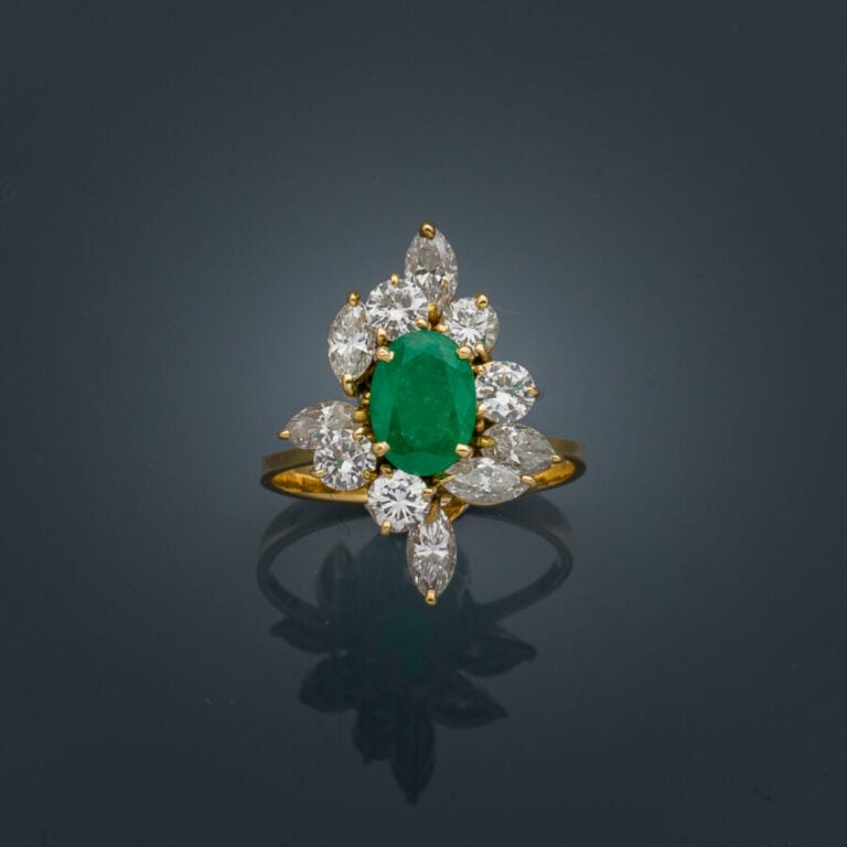 BAGUE "marquise" en or jaune (750‰) serti d'une émeraude ovale entourée de diam…