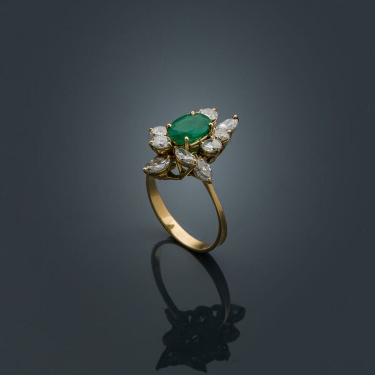 BAGUE "marquise" en or jaune (750‰) serti d'une émeraude ovale entourée de diam…