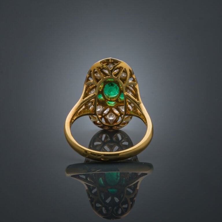 BAGUE "marquise" en or jaune et or gris (750‰) finement ajouré, serti d'une éme…