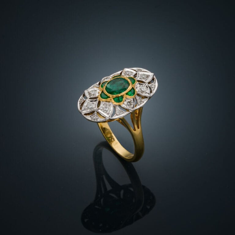 BAGUE "marquise" en or jaune et or gris (750‰) finement ajouré, serti d'une éme…