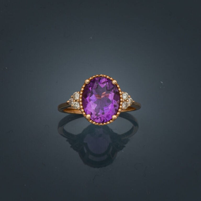 BAGUE ovale en or rose (750‰) serti d'une améthyste ovale épaulée de trois diam…