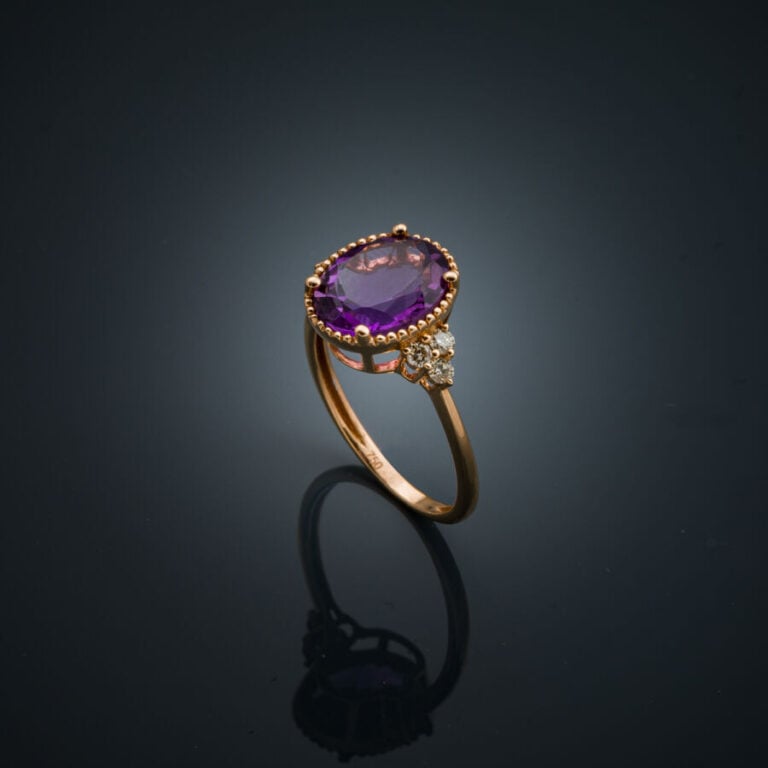 BAGUE ovale en or rose (750‰) serti d'une améthyste ovale épaulée de trois diam…