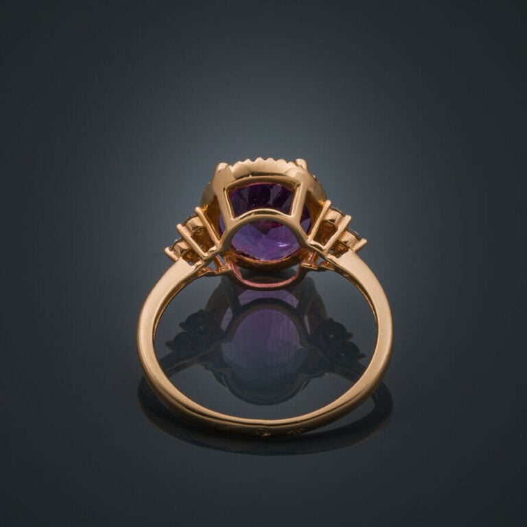 BAGUE ovale en or rose (750‰) serti d'une améthyste ovale épaulée de trois diam…