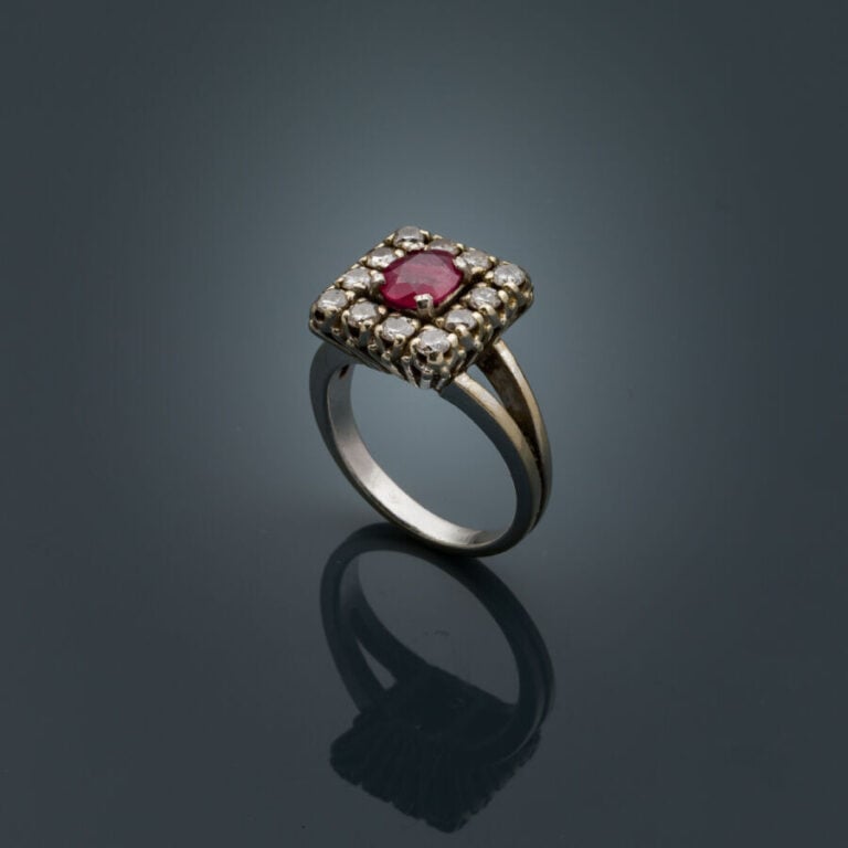 BAGUE rectangulaire en or gris (750‰) serti d'un rubis ovale entouré de diamant…