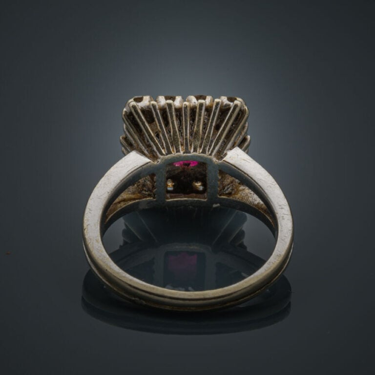 BAGUE rectangulaire en or gris (750‰) serti d'un rubis ovale entouré de diamant…