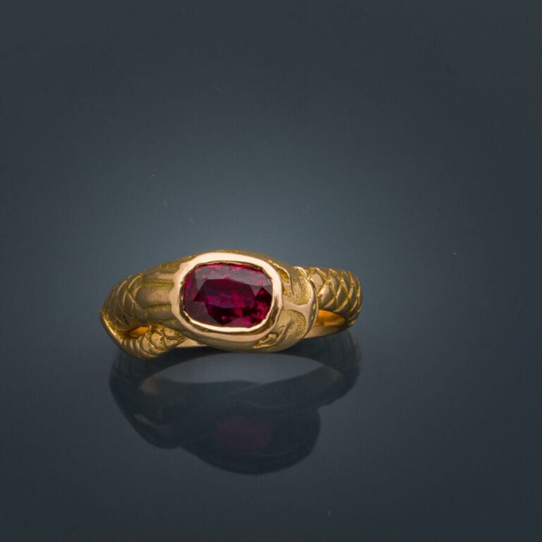 BAGUE "serpent" en or jaune (750‰) ciselé, serti d'un rubis de forme coussin (é…