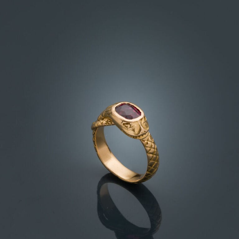 BAGUE "serpent" en or jaune (750‰) ciselé, serti d'un rubis de forme coussin (é…