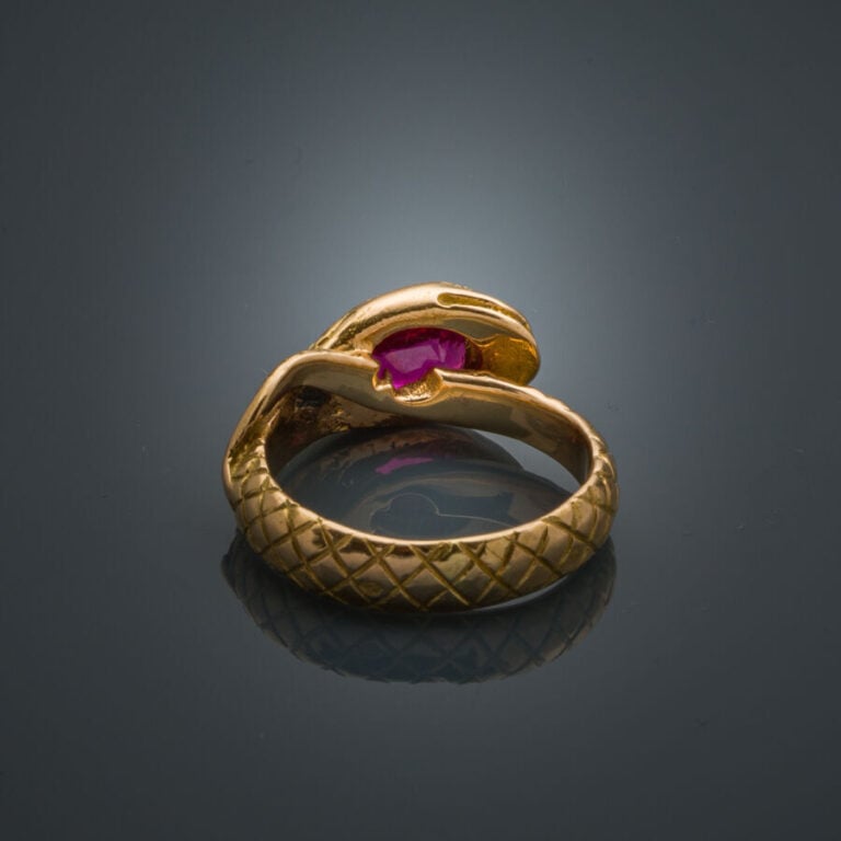 BAGUE "serpent" en or jaune (750‰) ciselé, serti d'un rubis de forme coussin (é…