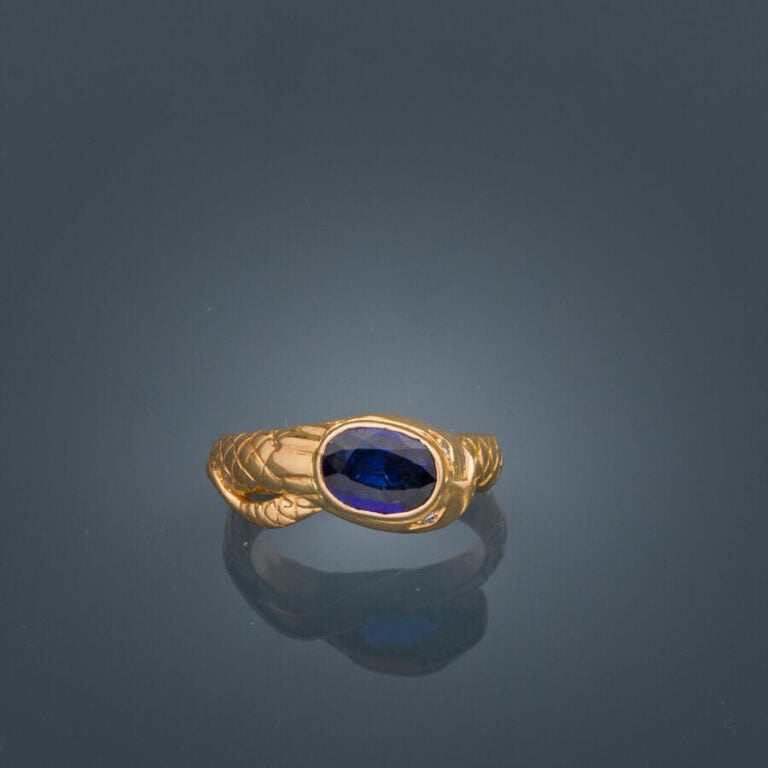 BAGUE "serpent" en or jaune (750‰) ciselé, serti d'un saphir ovale, les yeux se…