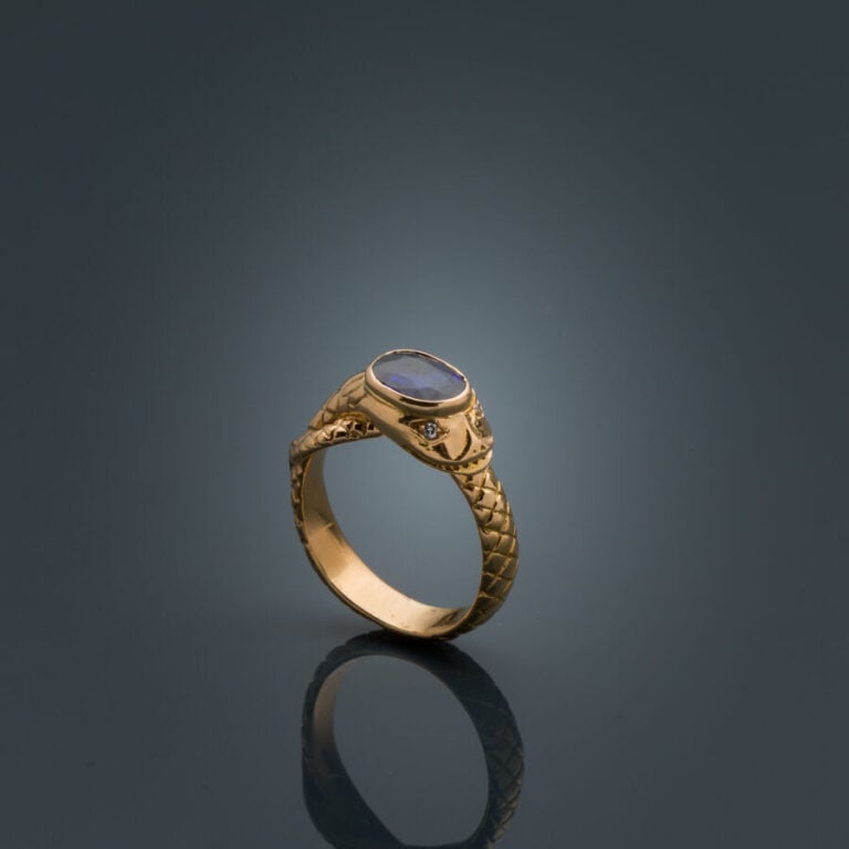 BAGUE "serpent" en or jaune (750‰) ciselé, serti d'un saphir ovale, les yeux se…