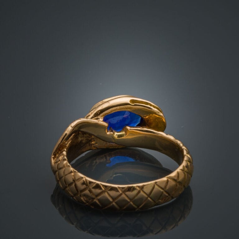 BAGUE "serpent" en or jaune (750‰) ciselé, serti d'un saphir ovale, les yeux se…