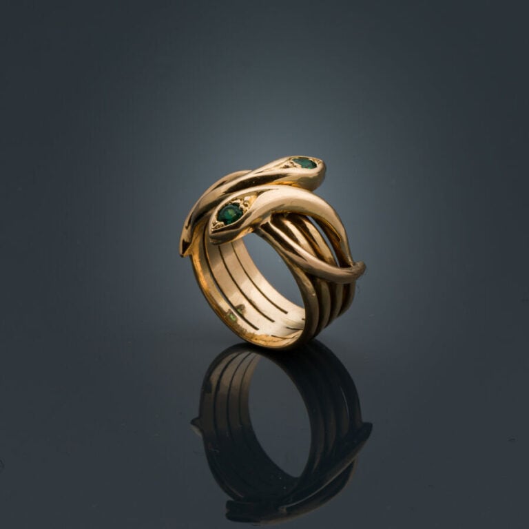 BAGUE "serpents entrelacés" en or jaune (750‰) ajouré, serti de deux émeraudes…