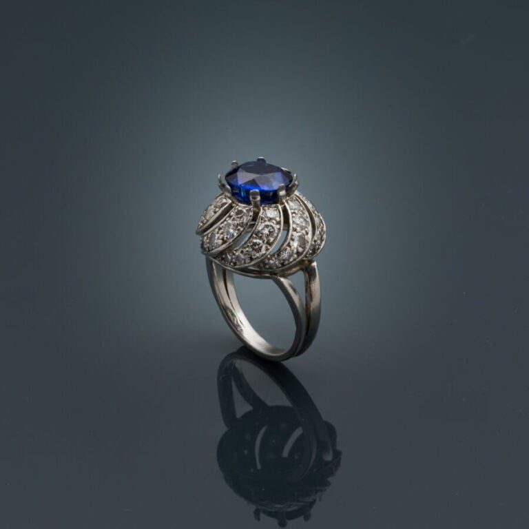 BAGUE "Tourbillon" en platine (950‰) ajouré, serti d'un saphir ovale, entouré d…