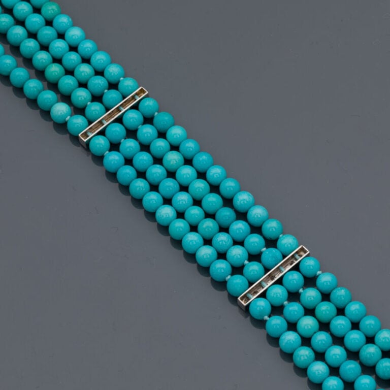BRACELET composé de quatre rangs de perles de turquoises retenus par trois barr…
