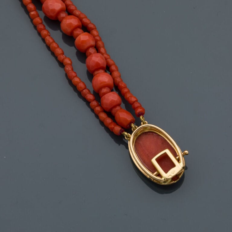BRACELET composé de trois rangs de perles de corail facetté. Fermoir en or jaun…