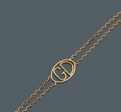 BRACELET double chaînette en or jaune (750‰) retenant au centre le monogramme "…