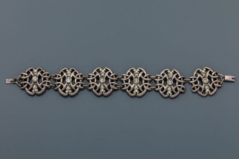 BRACELET en argent (850‰) ajouré à motifs de volutes enchevêtrées, ornés de str…